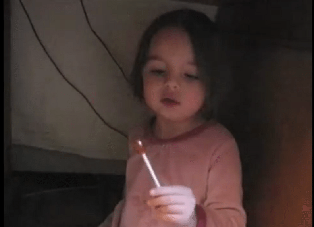 Adorable little girl gets caught eating sweets under table, little girl caught eating candy under table